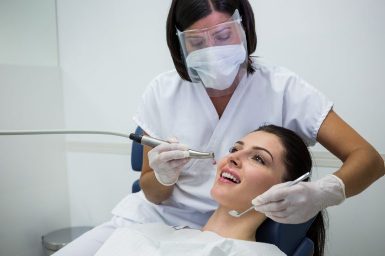 dentist-examining-female-patient-with-tools-min